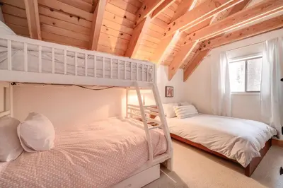 two bunk beds in a room with wooden ceilings at Ski, Hike and Fish Cabin with Deck in Soda Springs! in Soda Springs