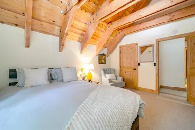 a bedroom with a large bed and wooden ceilings at Ski, Hike and Fish Cabin with Deck in Soda Springs! in Soda Springs