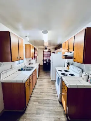 a kitchen with wooden cabinets and white counter tops at Home in Yosemite-Brookside Cottage-Sleeps 10 in Yosemite West