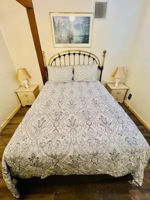 a bedroom with a bed with two nightstands and two lamps at Home in Yosemite-Brookside Cottage-Sleeps 10 in Yosemite West