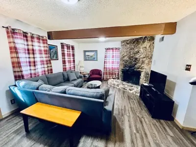 a living room with a blue couch and a fireplace at Home in Yosemite-Brookside Cottage-Sleeps 10 in Yosemite West