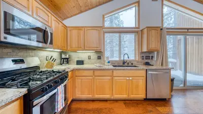 a kitchen with wooden cabinets and stainless steel appliances at Oslo Haus by AvantStay Cabin Retreat Near Northstar Downtown Truckee in Truckee