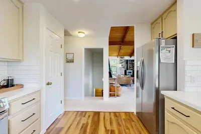 a kitchen with a stainless steel refrigerator and wooden floors at Restoration House in Groveland