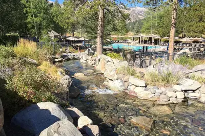 a stream of water with rocks and a swimming pool at Ski-InandSki-Out and Mtn Views! Everline Resort Condo in Olympic Valley