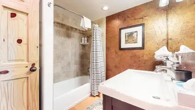 a bathroom with a white sink and a tub and a shower at Villa de los Pinos #09 condo in Mammoth Lakes