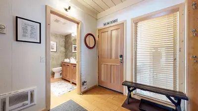 a hallway with a bathroom with a toilet and a door at Villa de los Pinos #09 condo in Mammoth Lakes
