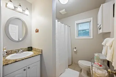 a bathroom with a sink and a toilet and a mirror at Midtown Apartment with Private Parking and King Bed in Sacramento