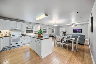 a kitchen and dining room with white cabinets and a table at Midtown Apartment with Private Parking and King Bed in Sacramento
