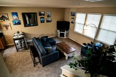 a living room with blue couches and a tv at Eat-Sleep-Stroll-Repeat! Walkable Midtown 2BR Home in Reno