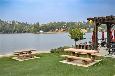 two picnic tables and a gazebo next to a lake at Whispering Pines Retreat home in Groveland