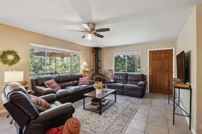 a living room with leather furniture and a ceiling fan at Whispering Pines Retreat home in Groveland