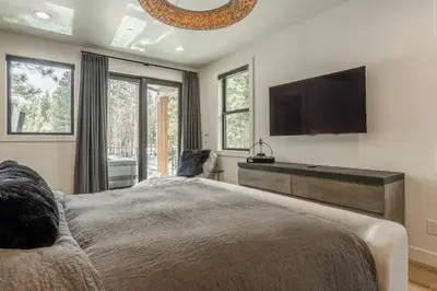 a bedroom with a large bed and a flat screen tv at New Luxury 4BR /3BA Obsidian Reserve #110 – Hot Tub, 2-Car Garage, Pool Table, Mount Views! in Mammoth Lakes