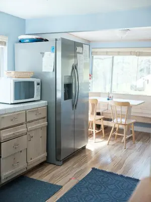 a kitchen with a stainless steel refrigerator and a table at Near Yosemite Bass Lake Cabin with Hot Tub, Lake View, Pet Friendly in Bass Lake