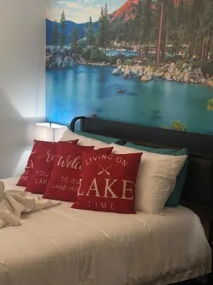 a bed with two pillows and a painting of a lake at The Rivet in Reno