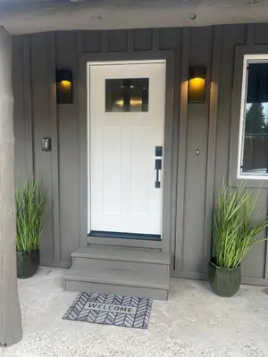 a white door on a house with two plants at Emerald Bay Escape in South Lake Tahoe