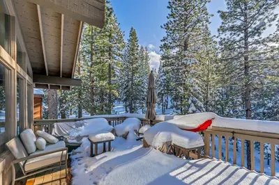 a bird sitting on a deck covered in snow at The Lazy Bear Northstar Resort Truckee in Truckee