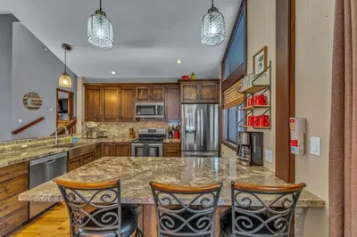 a kitchen with a large island with two bar stools at The Lazy Bear Northstar Resort Truckee in Truckee