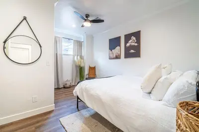 a white bedroom with a bed and a ceiling fan at Stylish 2-Bedroom walking distance to Downtown in Reno