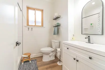 a white bathroom with a toilet and a sink at Stylish 2-Bedroom walking distance to Downtown in Reno