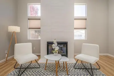 a living room with two white chairs and a fireplace at Designer Home conveniently located in Reno NV in Reno