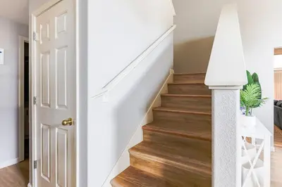 a staircase in a home with white walls and wood floors at Designer Home conveniently located in Reno NV in Reno