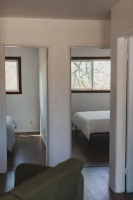 a bedroom with a bed and two windows at Secluded rustic 2-bedroom cabin on private land in Miramonte