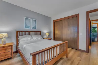 a bedroom with a large bed and a wooden closet at Chinquapin Condo Retreat - Walk to the Lake in Tahoe City