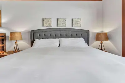 a bedroom with a large white bed with two lamps at Chinquapin Condo Retreat - Walk to the Lake in Tahoe City