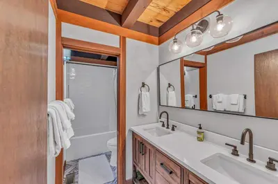 a bathroom with a sink and a toilet and a mirror at Chinquapin Condo Retreat - Walk to the Lake in Tahoe City