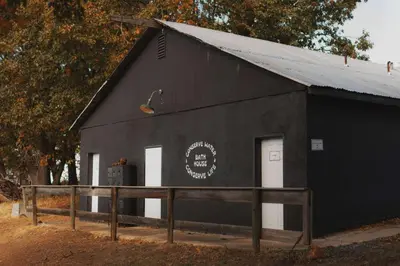 a black building with two white doors on it at Cosy yurt at a nature retreat in Sequoia N Forest in Miramonte