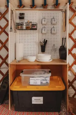 a shelf with bowls and other items on it at Cosy yurt at a nature retreat in Dunlap CA in Miramonte