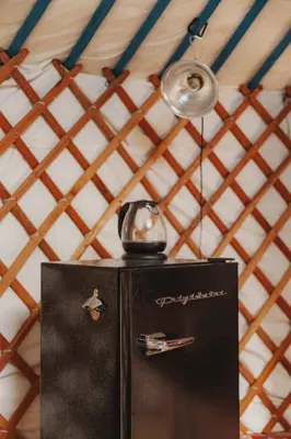 a black refrigerator with a tea kettle on top of it at Cosy yurt at a nature retreat in Dunlap CA in Miramonte