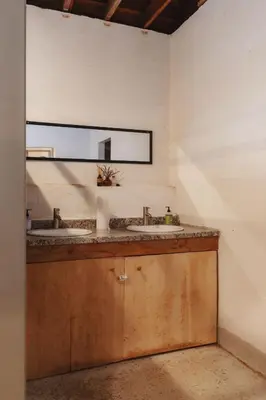 a bathroom with two sinks and a mirror at Cosy yurt at a nature retreat in CA in Miramonte