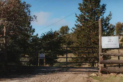 a gate with a sign in front of a field at Glamping yurt at a nature retreat near Sequoia in Miramonte