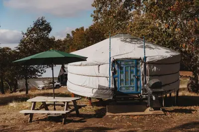 a tent with a picnic table and an umbrella at Cosy yurt at a nature retreat in Sequoia Forest in Miramonte