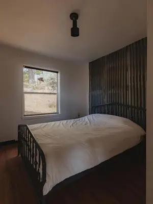 a bedroom with a large bed with a window at Secluded rustic 2-bedroom cabin on nature retreat in Miramonte