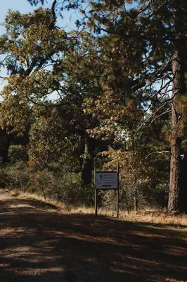 a sign on the side of a road with trees at Secluded rustic 2-bedroom cabin on nature retreat in Miramonte