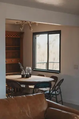 a room with a table and chairs and a window at Spacious 4-bedroom cabin on secluded private land in Miramonte
