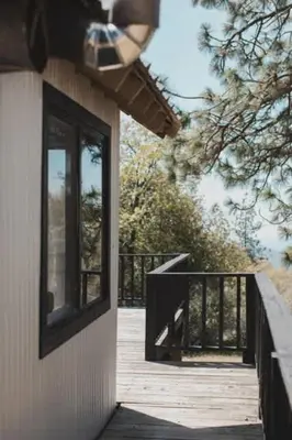a wooden porch with a window on the side of a house at Secluded rustic 2-bedroom cabin at nature retreat in Miramonte