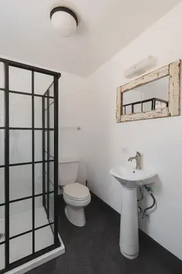 a bathroom with a toilet and a sink and a mirror at Secluded rustic 1-bedroom cabin on private land in Miramonte