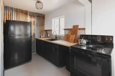 a kitchen with black appliances and a black refrigerator at Secluded rustic 1-bedroom cabin on private land in Miramonte