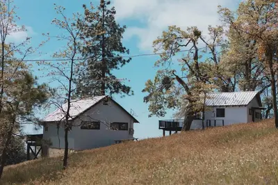 a house on top of a hill with trees at Secluded rustic 1-bedroom cabin on private land in Miramonte