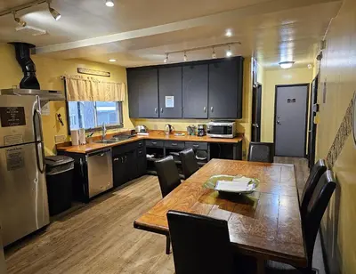 a kitchen with a wooden table and a dining room at Moderne Hostel in Mammoth Lakes