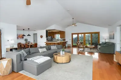 a living room with a couch and a table at New Big Sky Cabin at Yosemite w/ VIEWS, hot tub, firepit, and more in Oakhurst