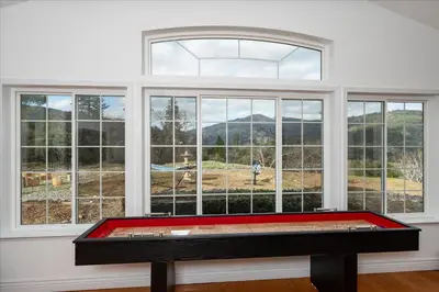 a room with a pool table in front of a window at New Big Sky Cabin at Yosemite w/ VIEWS, hot tub, firepit, and more in Oakhurst