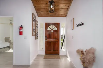 a hallway with a wooden door in a house at New Yosemite Dream Nest with HUGE views/spa/firepit/pet friendly in Oakhurst