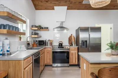 a kitchen with wooden cabinets and stainless steel appliances at New Yosemite Dream Nest with HUGE views/spa/firepit/pet friendly in Oakhurst
