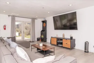 a living room with a couch and a tv on the wall at New Yosemite Dream Nest with HUGE views/spa/firepit/pet friendly in Oakhurst