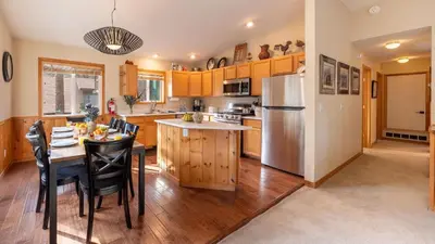 a kitchen with a table and a refrigerator at Stylish Truckee Retreat Deck Near Lake Skiing Moraine by AvantStay in Truckee