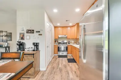 a kitchen with wooden cabinets and a stainless steel refrigerator at Coulterville Home with Gazebo Near Lakes and Hiking! in Coulterville